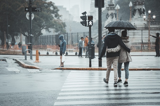 Two people walking under one umbrella in the rain