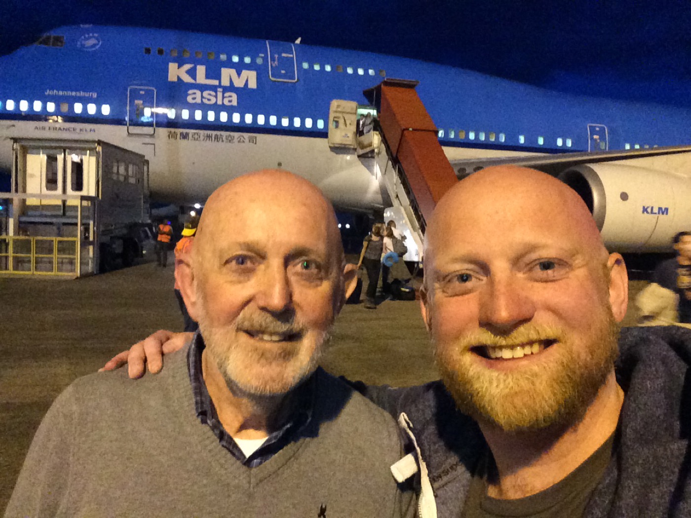 Henk and his son on the apron at Paramaribo airport at night, a KLM Boeing 747 behind them.
