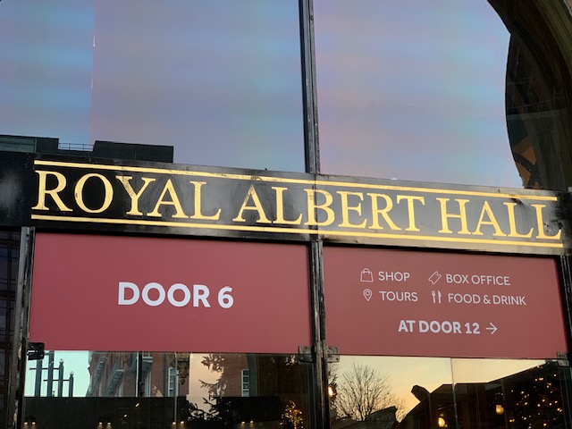 The Royal Albert Hall sign above an entrance, with Door 6 beneath it and directions to the shop and box office.