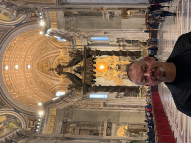 Inside St Peter's Basilica, with Bernini's bronze baldachin and the golden light of the high altar behind it.