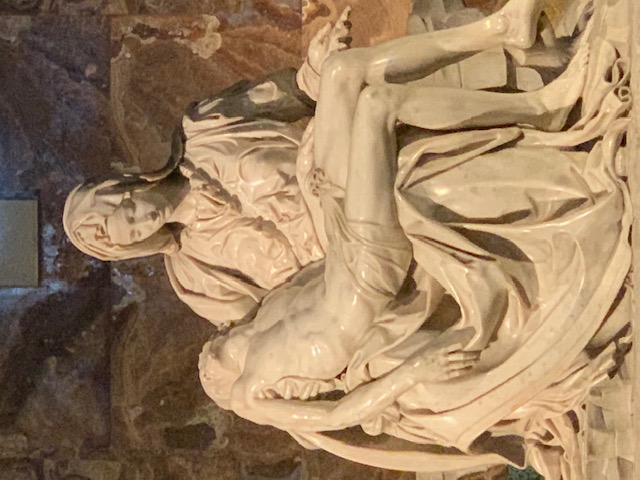 Michelangelo's Pietà in white marble, with Mary holding the body of Christ on her lap.