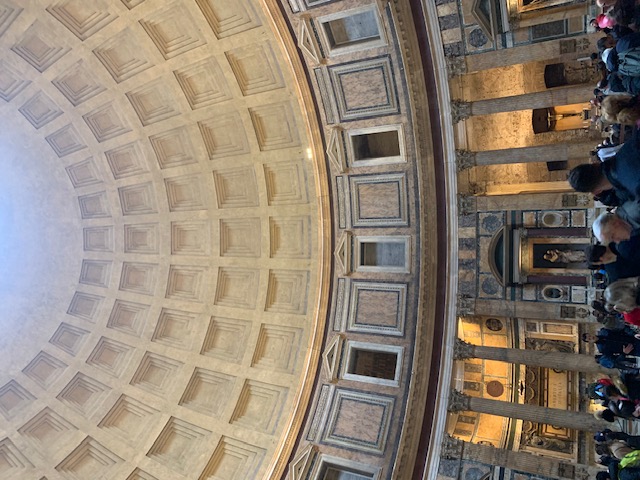 The impressive coffered dome of the Pantheon, with daylight falling through the opening in the middle.