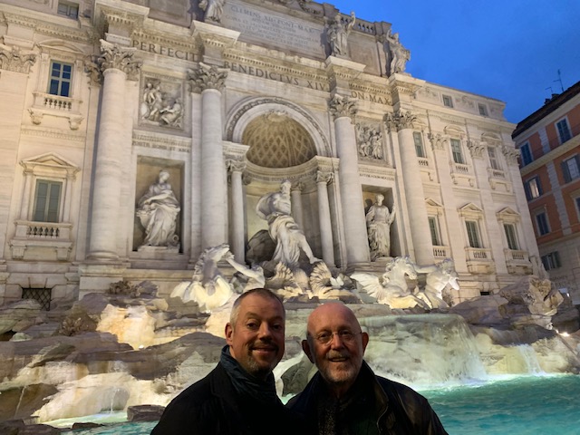 At dusk in front of the lit Trevi Fountain in Rome.