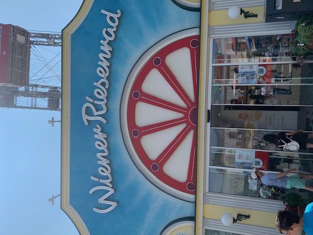 The painted entrance pavilion of the Wiener Riesenwheel, its red wheel emblem above the doors.